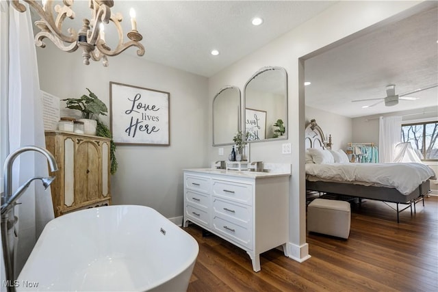 full bath with ceiling fan, wood finished floors, vanity, a soaking tub, and ensuite bath