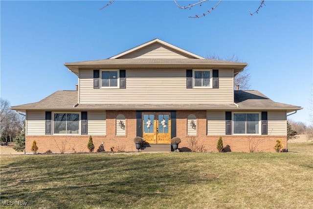 view of front of house with a front yard and brick siding