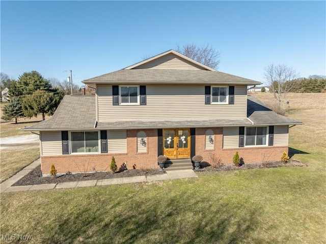 view of front of home featuring a front yard and brick siding