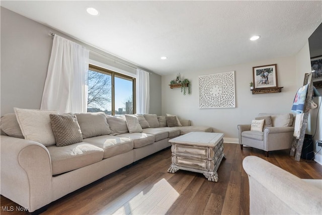 living room with recessed lighting, dark wood finished floors, a textured ceiling, and baseboards