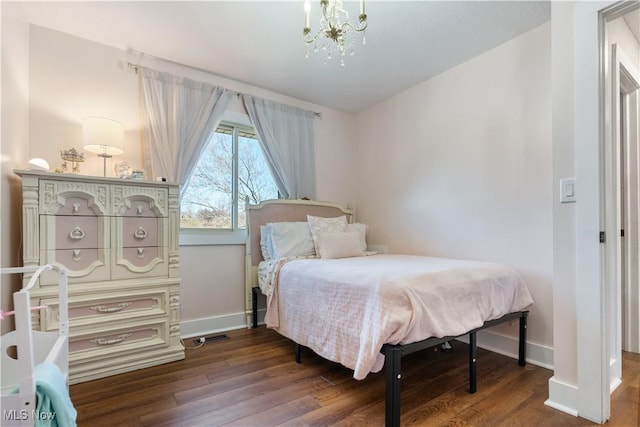 bedroom with a notable chandelier, baseboards, and wood finished floors