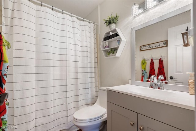 full bathroom featuring curtained shower, vanity, and toilet