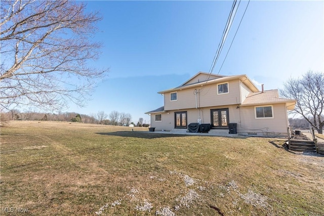 rear view of property featuring a patio, french doors, and a lawn