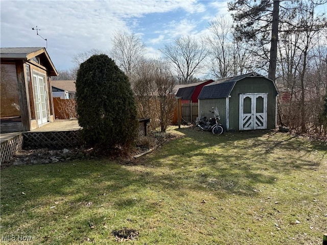 view of yard with a storage shed, an outdoor structure, and fence