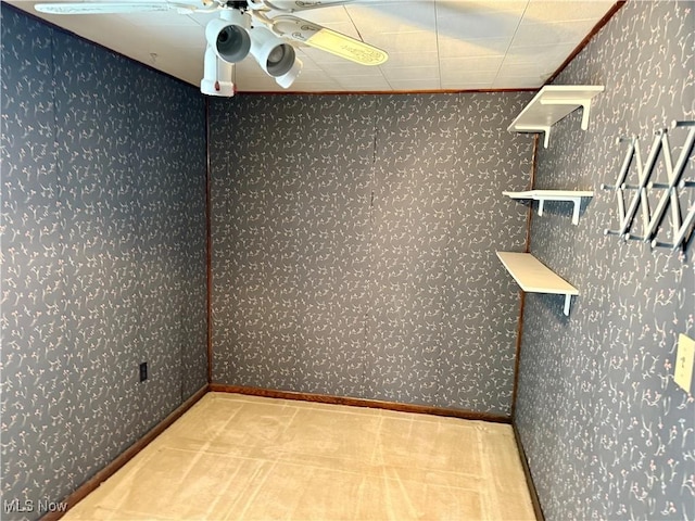 empty room featuring carpet floors, ceiling fan, baseboards, and wallpapered walls