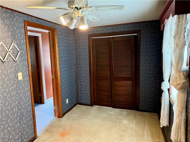 unfurnished bedroom with carpet floors, wallpapered walls, ceiling fan, and ornamental molding