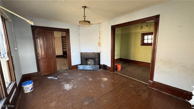 unfurnished living room featuring a fireplace and baseboards