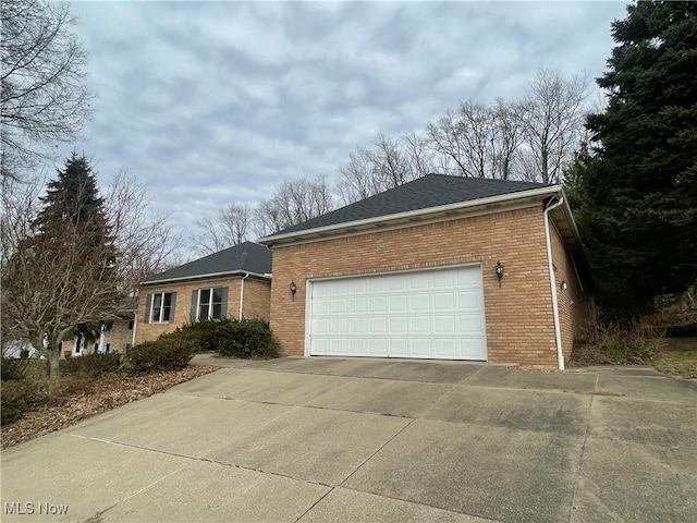 ranch-style home featuring a shingled roof, brick siding, driveway, and an attached garage