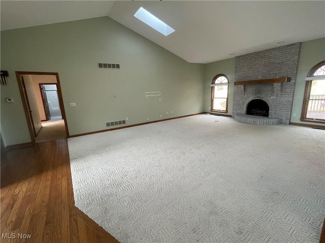 unfurnished living room with plenty of natural light, a fireplace, and visible vents