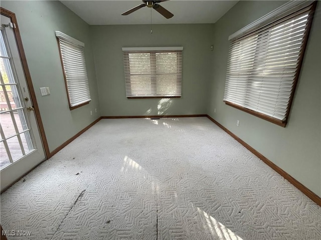 spare room featuring ceiling fan, baseboards, and light colored carpet