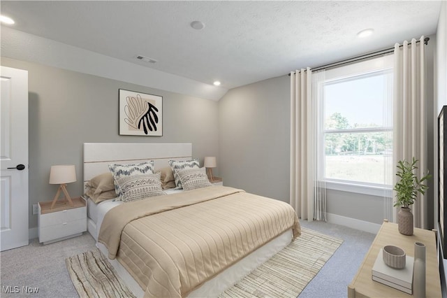 bedroom with lofted ceiling, a textured ceiling, light colored carpet, visible vents, and baseboards