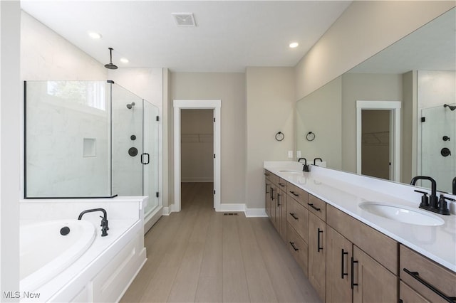 full bath featuring visible vents, a sink, a shower stall, and baseboards