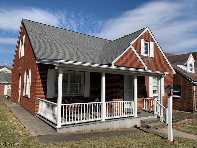 bungalow-style house with a porch, brick siding, and a shingled roof