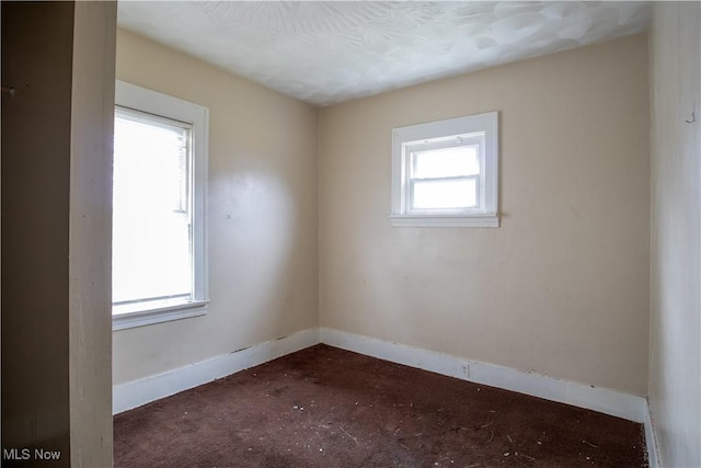 unfurnished room featuring baseboards