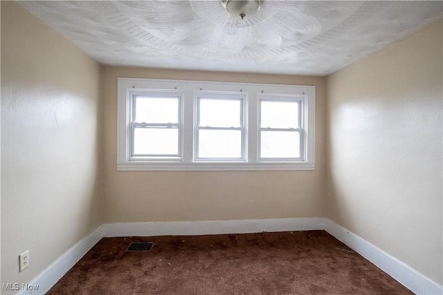 carpeted empty room featuring visible vents and baseboards