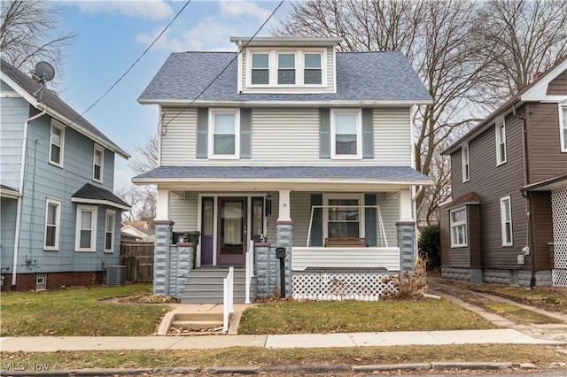 traditional style home with covered porch, a shingled roof, and cooling unit