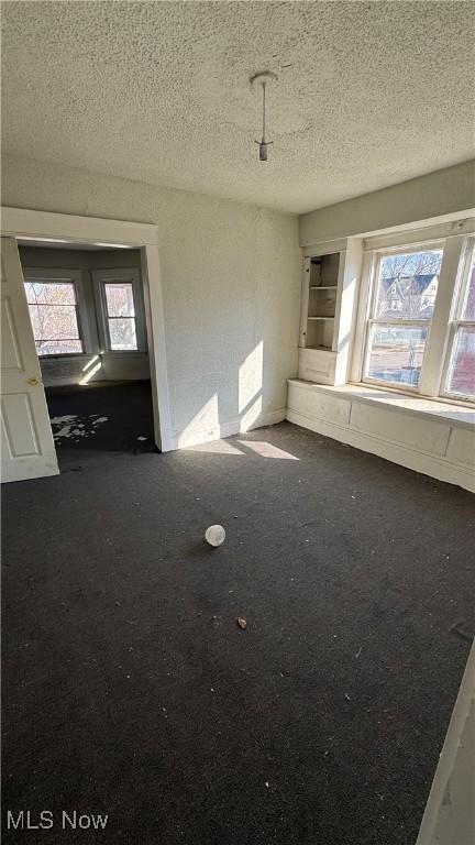 unfurnished room featuring a textured ceiling