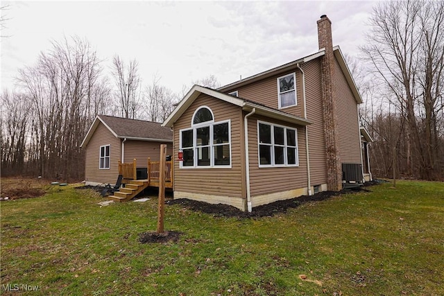 back of house featuring a yard, a chimney, and cooling unit