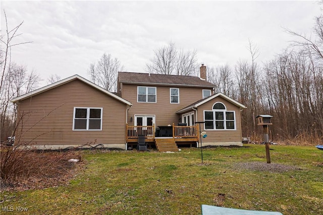 back of house with a chimney, a lawn, and a wooden deck