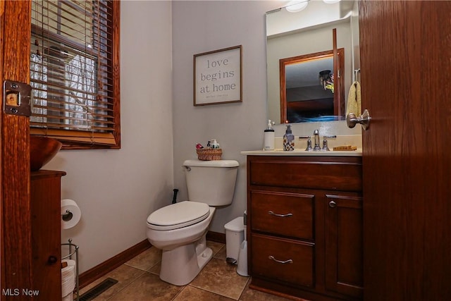 bathroom with visible vents, toilet, vanity, baseboards, and tile patterned floors