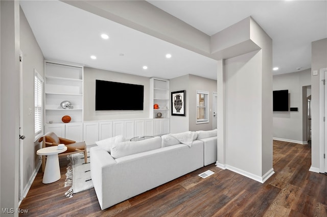 living room with built in features, dark wood finished floors, recessed lighting, visible vents, and baseboards