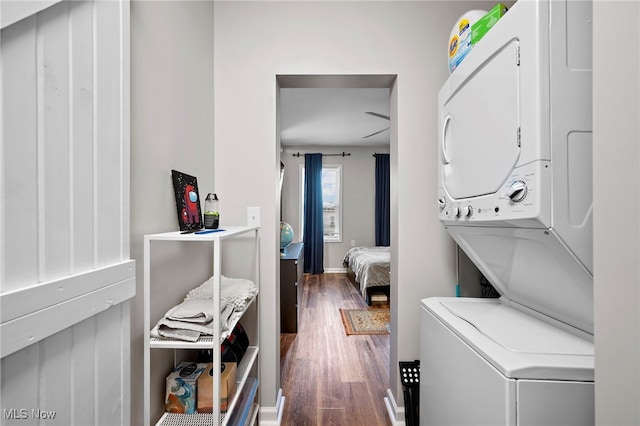 laundry room featuring laundry area, stacked washer / dryer, and wood finished floors