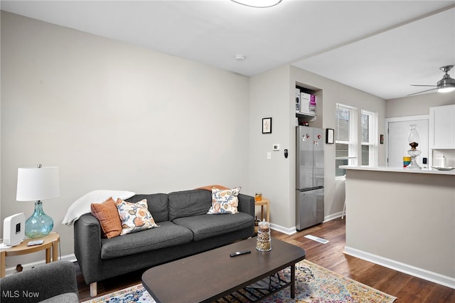 living room with ceiling fan, dark wood finished floors, and baseboards