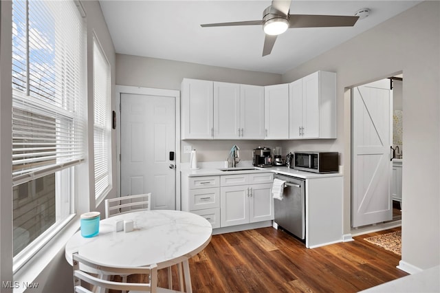 kitchen with white cabinetry, stainless steel appliances, a sink, and light countertops