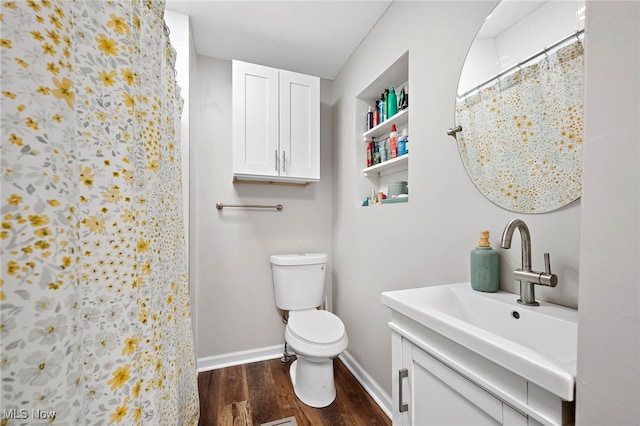 bathroom featuring baseboards, a shower with shower curtain, toilet, wood finished floors, and vanity