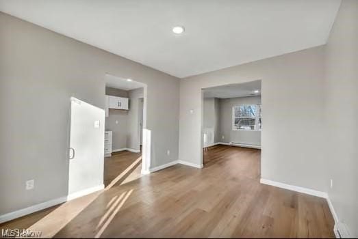 spare room featuring baseboards and wood finished floors