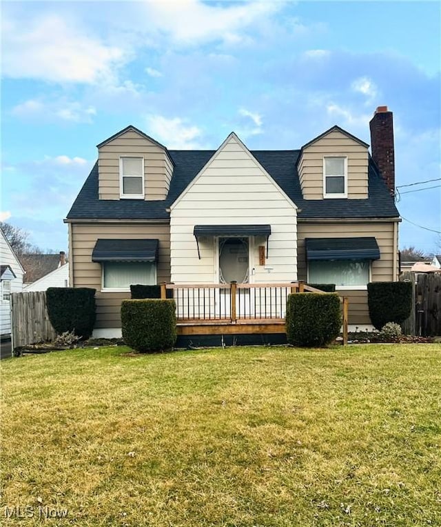 view of front of house featuring a front lawn, a chimney, and fence