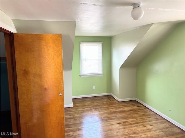 bonus room with lofted ceiling, wood finished floors, and baseboards