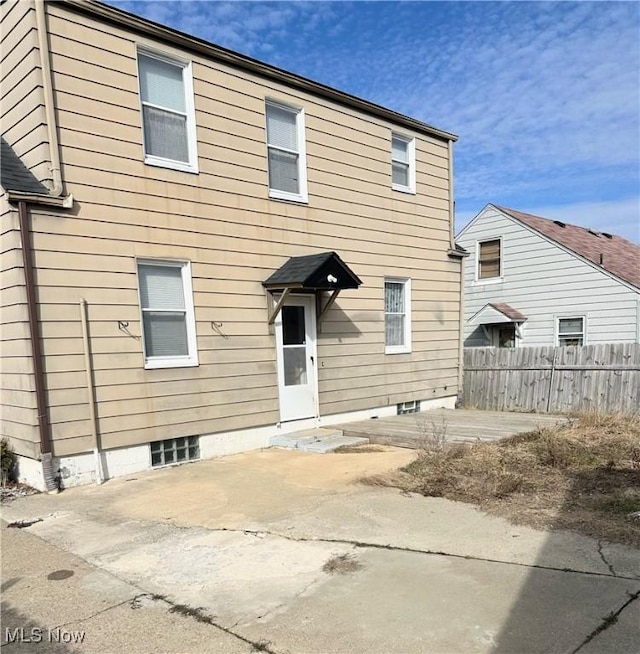 rear view of house with a patio and fence