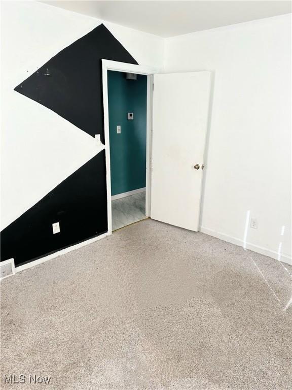 carpeted spare room featuring baseboards