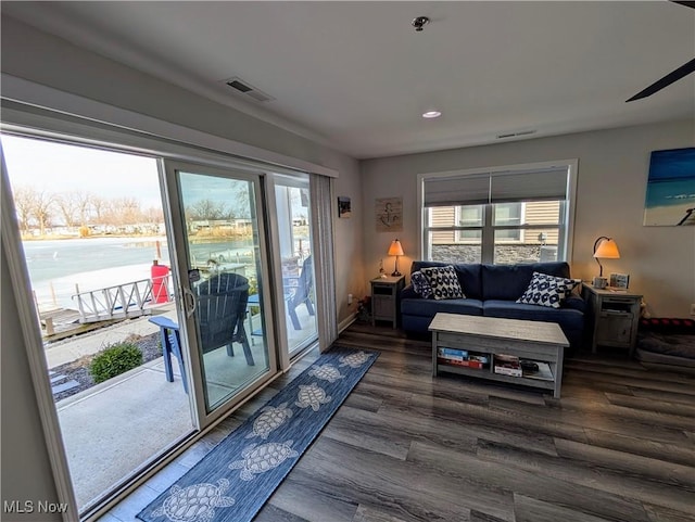 living room featuring visible vents, baseboards, and wood finished floors