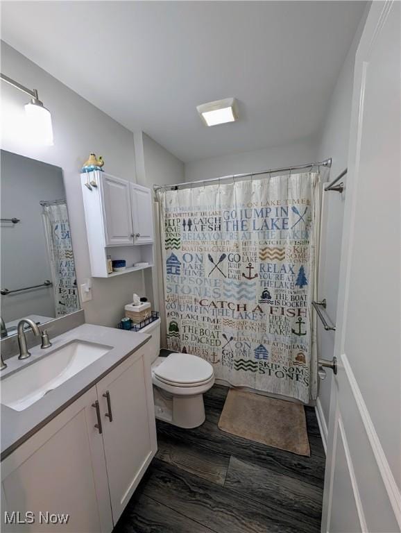 full bathroom with toilet, a shower with curtain, wood finished floors, and vanity