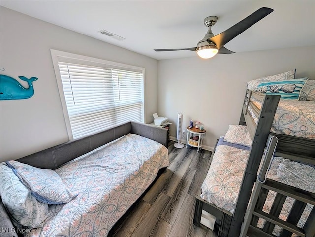 bedroom featuring ceiling fan, visible vents, and wood finished floors