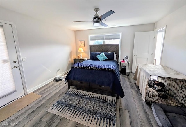 bedroom featuring a ceiling fan, baseboards, and wood finished floors