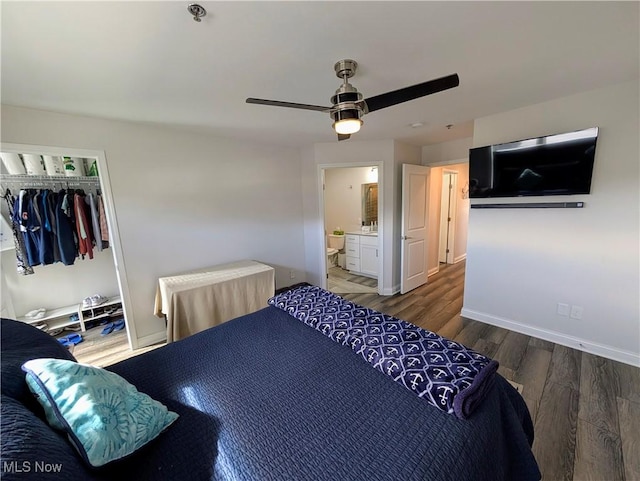 bedroom featuring ensuite bathroom, wood finished floors, a ceiling fan, baseboards, and a closet