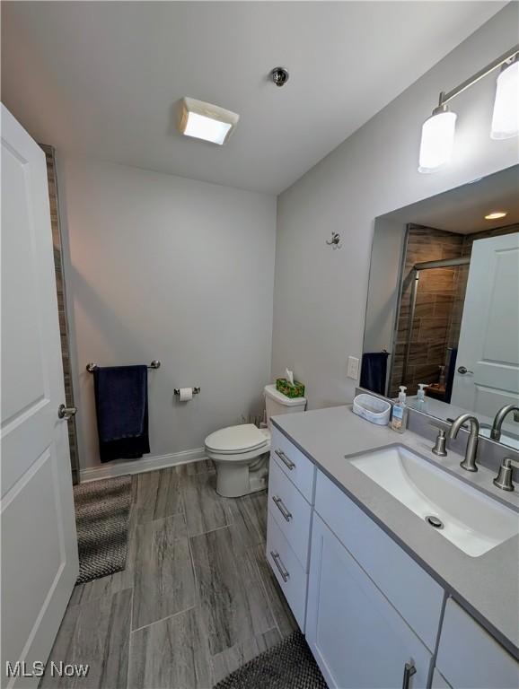 2568 S Waterside Ct Unit 211, Lakeside-Marblehead, OH 43440 - bathroom with vanity, a tile shower, toilet, and wood finished floors