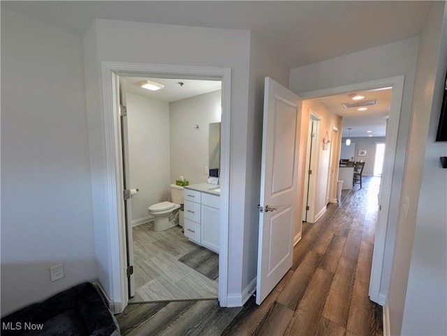 corridor with dark wood-style floors and baseboards