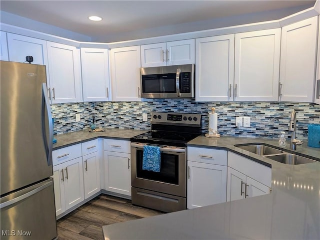 2568 S Waterside Ct Unit 211, Lakeside-Marblehead, OH 43440 - kitchen featuring stainless steel appliances, a sink, dark wood finished floors, white cabinets, and backsplash