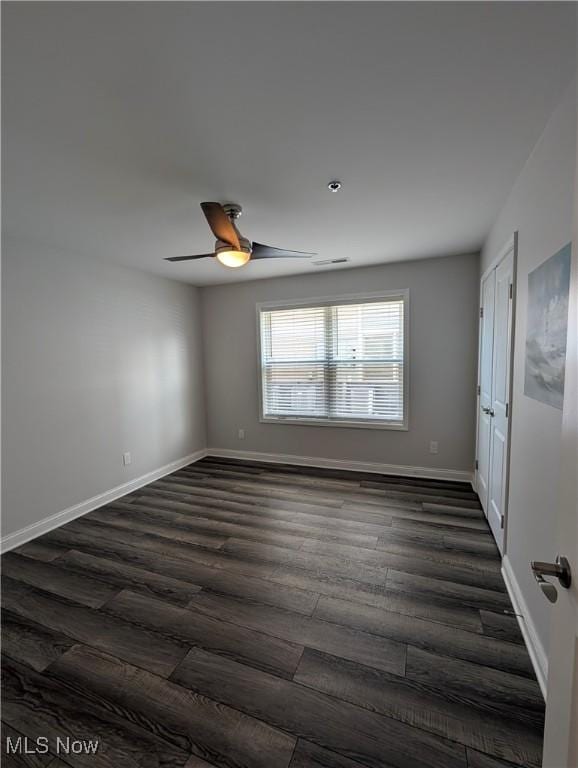 2568 S Waterside Ct Unit 211, Lakeside-Marblehead, OH 43440 - unfurnished room featuring dark wood-style floors, a ceiling fan, and baseboards