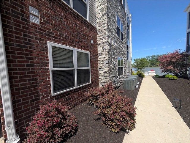 2568 S Waterside Ct Unit 211, Lakeside-Marblehead, OH 43440 - view of side of property with stone siding, brick siding, and cooling unit