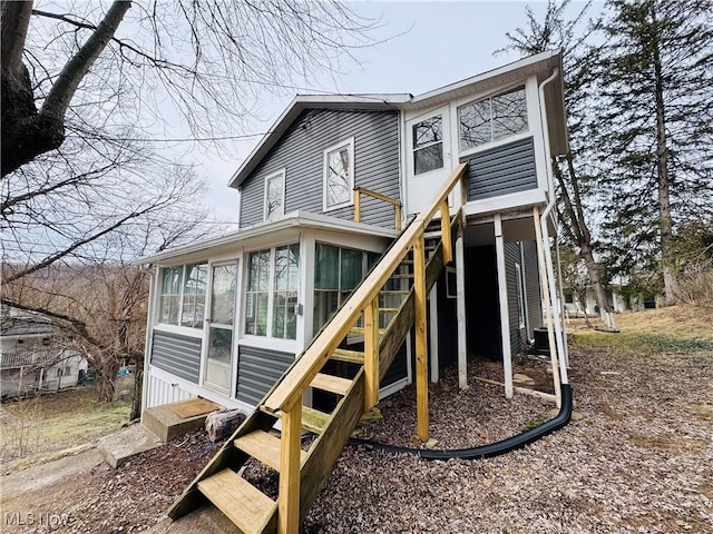 rear view of house featuring entry steps and a sunroom