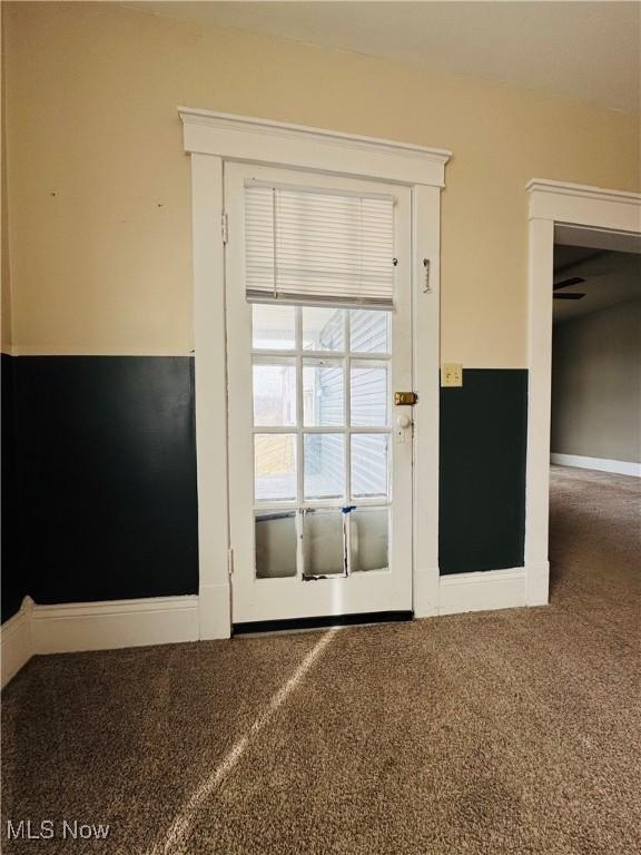 doorway to outside with carpet and baseboards