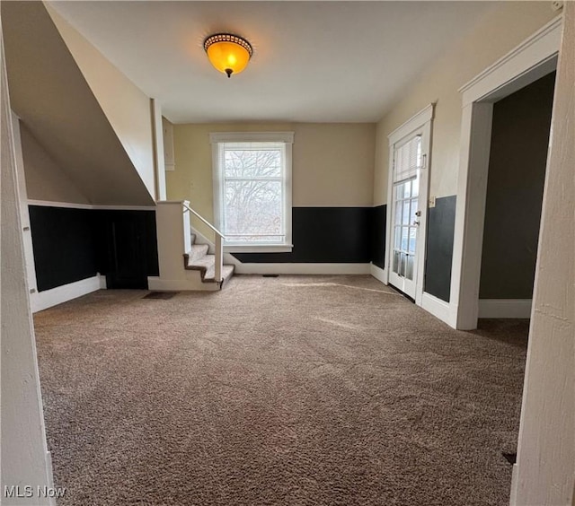 spare room featuring carpet floors, stairway, and baseboards