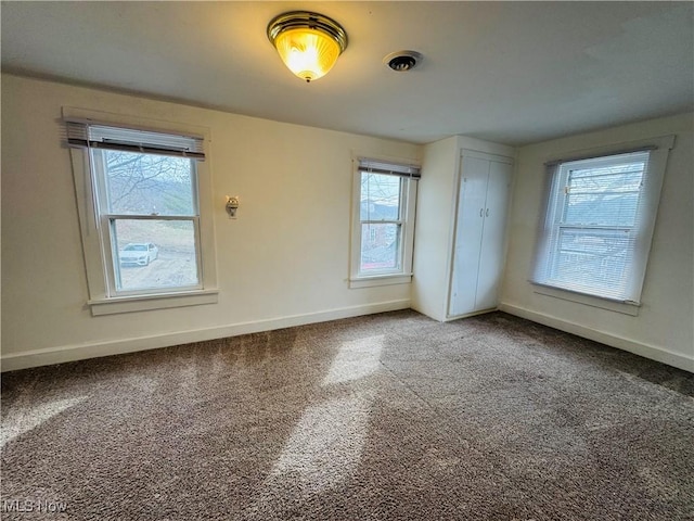 spare room featuring carpet and baseboards