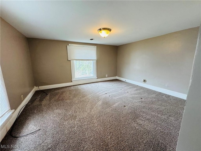 unfurnished room with carpet floors and baseboards