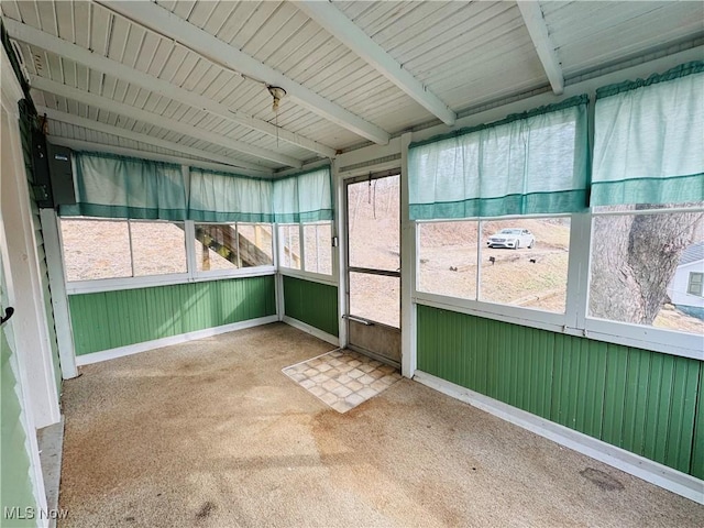 unfurnished sunroom featuring beamed ceiling